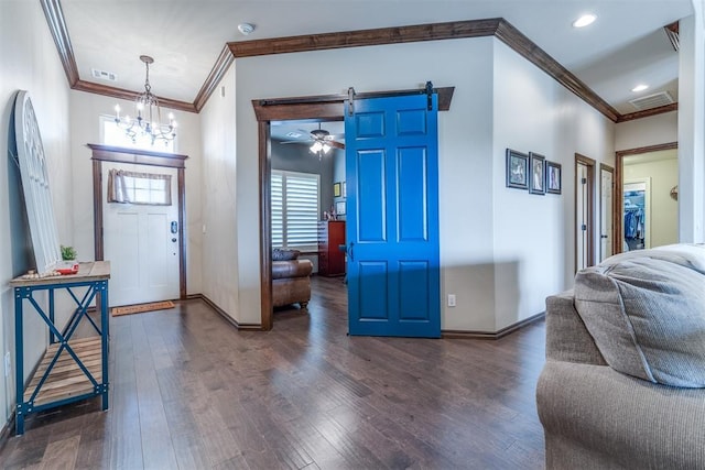 entryway with baseboards, ornamental molding, wood finished floors, and a barn door