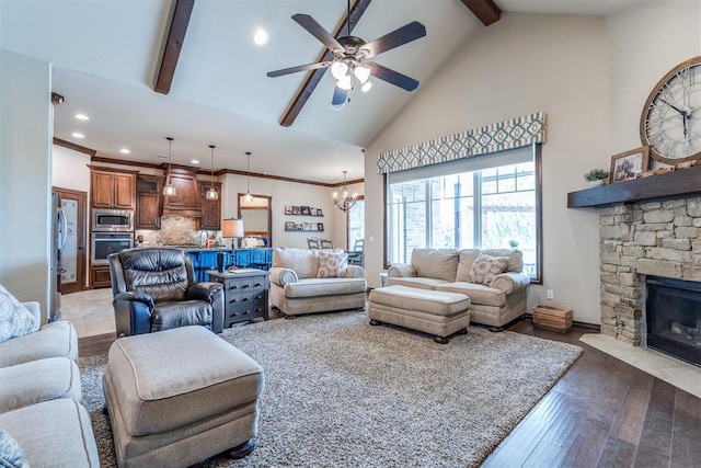 living room with a stone fireplace, light wood-type flooring, beamed ceiling, ceiling fan with notable chandelier, and recessed lighting