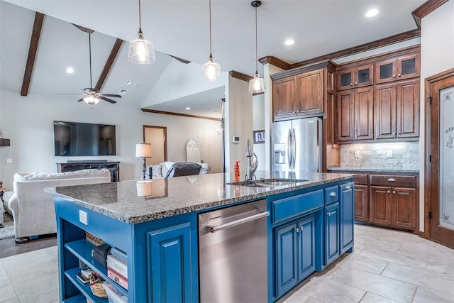 kitchen featuring a sink, stainless steel appliances, blue cabinetry, and an island with sink