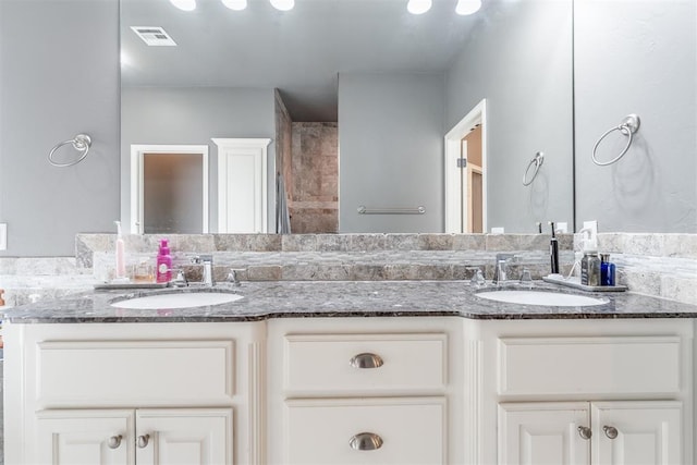 bathroom featuring a sink, double vanity, and visible vents