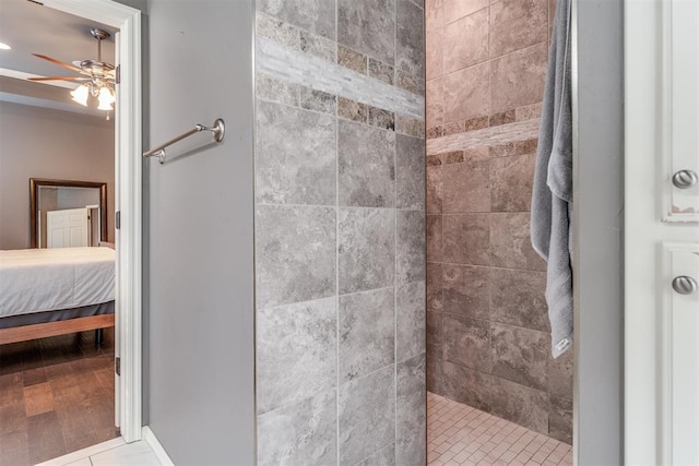 ensuite bathroom with connected bathroom, ceiling fan, and a tile shower