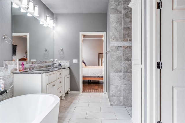 bathroom featuring double vanity, marble finish floor, ensuite bathroom, a soaking tub, and a sink