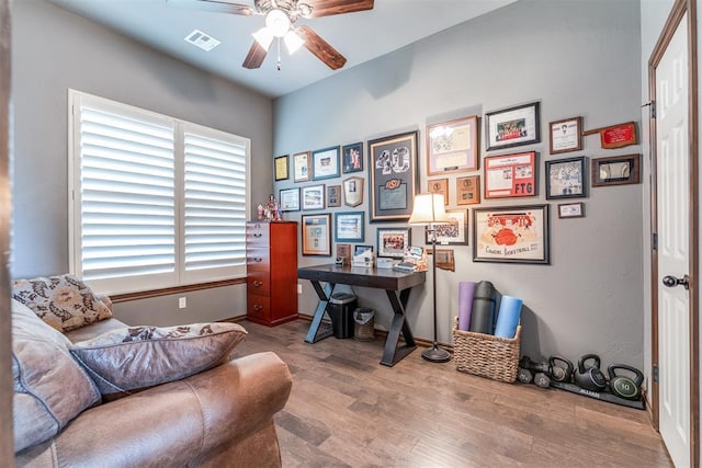 office with baseboards, a ceiling fan, wood finished floors, and visible vents