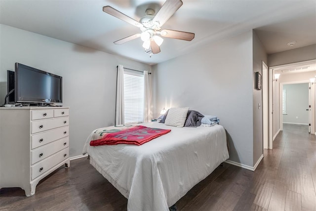bedroom featuring baseboards, ceiling fan, and dark wood-style floors
