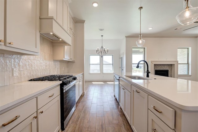 kitchen featuring decorative backsplash, dishwasher, a sink, light countertops, and gas range oven