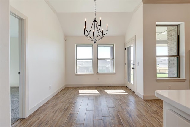 unfurnished dining area featuring an inviting chandelier, baseboards, light wood-style floors, and vaulted ceiling