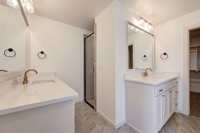 full bath with a tile shower, a spacious closet, two vanities, and a sink