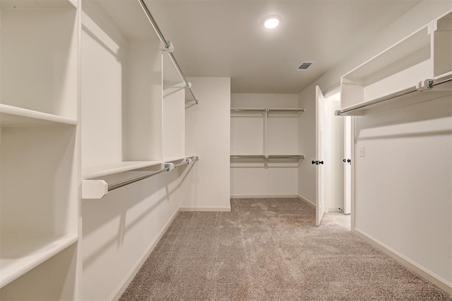 walk in closet featuring visible vents and light colored carpet