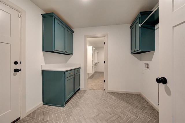 laundry area featuring baseboards, hookup for a washing machine, and cabinet space