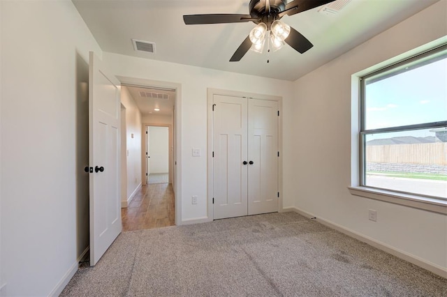 unfurnished bedroom featuring baseboards, carpet, a closet, and visible vents