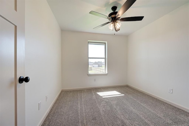 carpeted empty room featuring baseboards and ceiling fan
