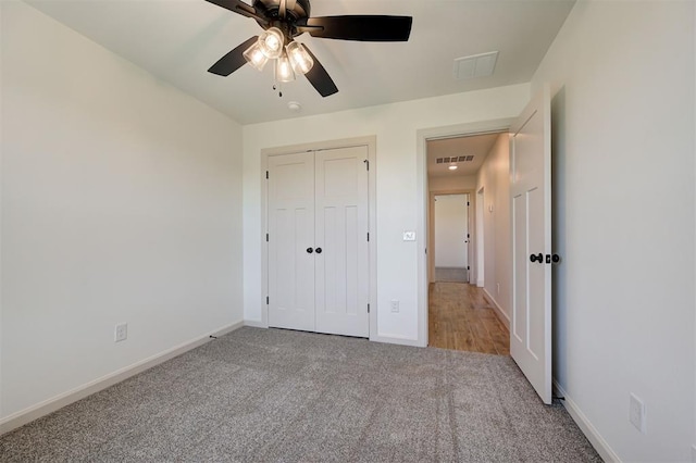 unfurnished bedroom featuring ceiling fan, visible vents, carpet floors, baseboards, and a closet
