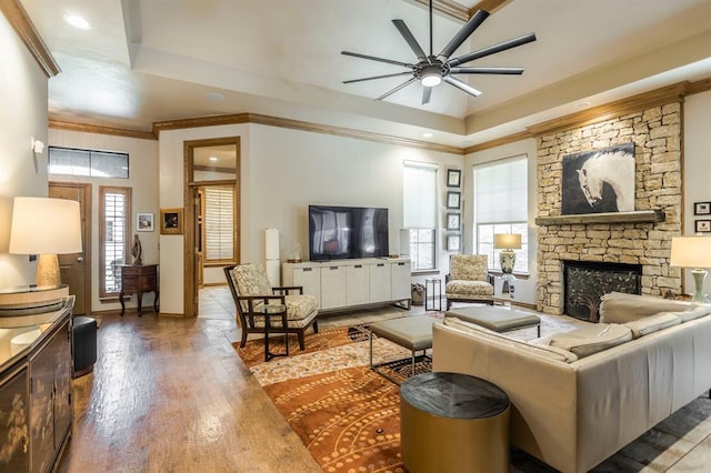 living area with a fireplace, a ceiling fan, a healthy amount of sunlight, and wood finished floors