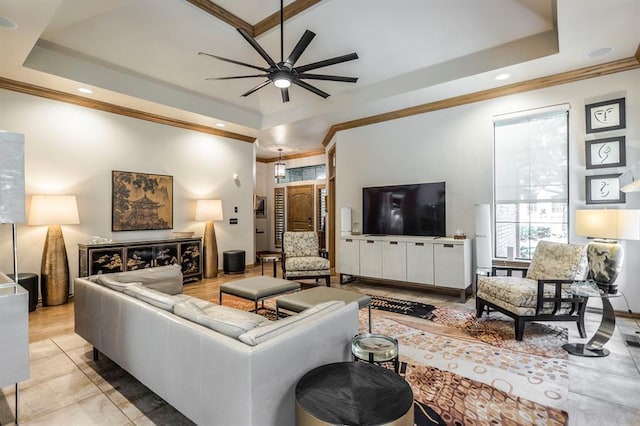 living room with ornamental molding, a ceiling fan, a tray ceiling, and recessed lighting