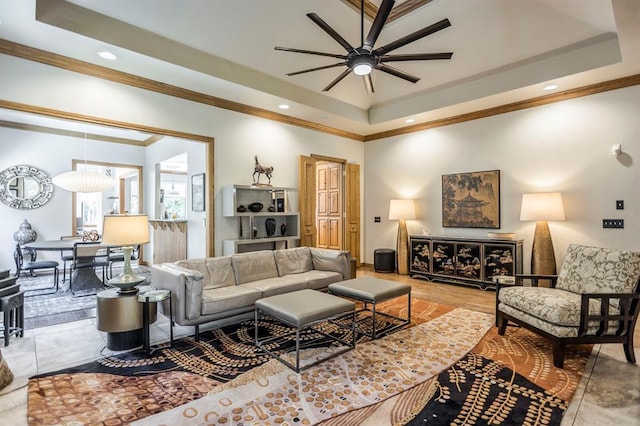 living area featuring a ceiling fan, a tray ceiling, recessed lighting, and ornamental molding