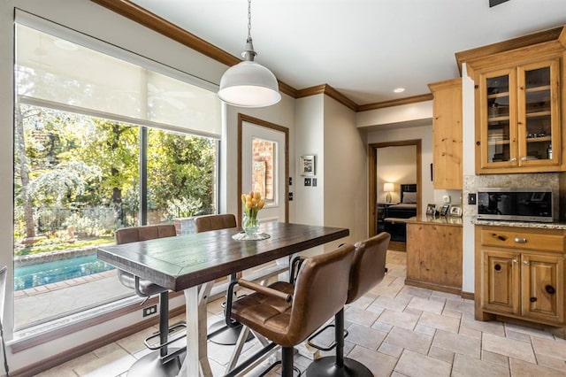 dining room with crown molding, stone finish floor, and plenty of natural light