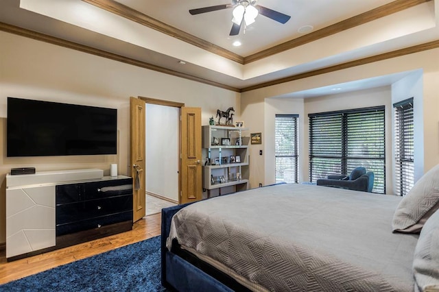 bedroom featuring ceiling fan, recessed lighting, wood finished floors, a tray ceiling, and ornamental molding