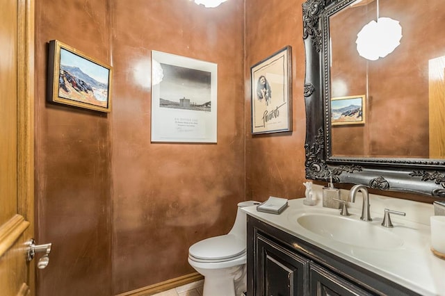 half bathroom featuring vanity, tile patterned flooring, and toilet