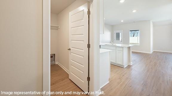 hall featuring baseboards and light wood-style floors