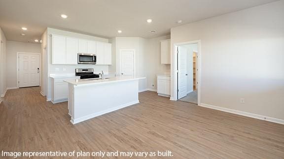 kitchen featuring white cabinets, stainless steel appliances, baseboards, and light wood-style flooring