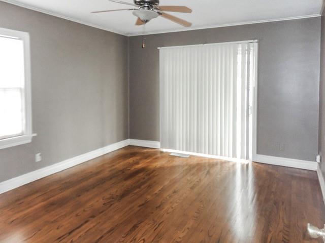unfurnished room with crown molding, a ceiling fan, and baseboards
