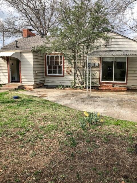 back of property featuring a chimney and a patio area