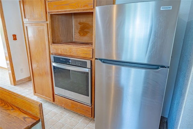 kitchen with light tile patterned flooring and stainless steel appliances