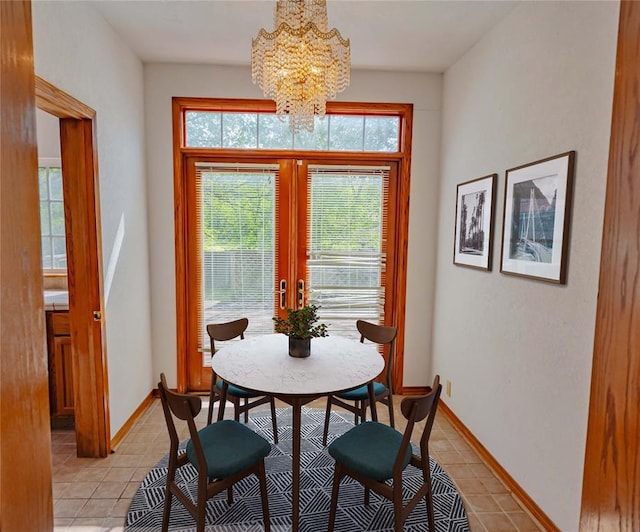 dining area with light tile patterned floors, baseboards, french doors, and a notable chandelier