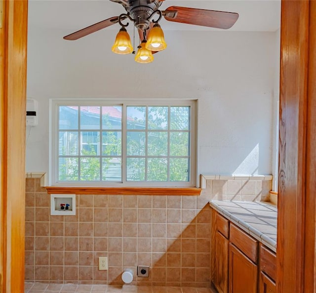 bathroom with a wainscoted wall, plenty of natural light, and a ceiling fan