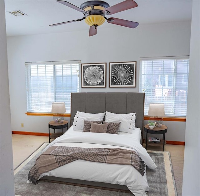 bedroom featuring baseboards, visible vents, and multiple windows