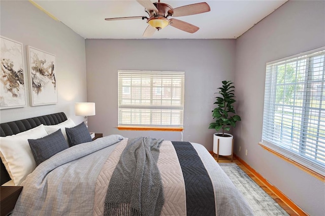 bedroom with baseboards, a ceiling fan, and light wood finished floors