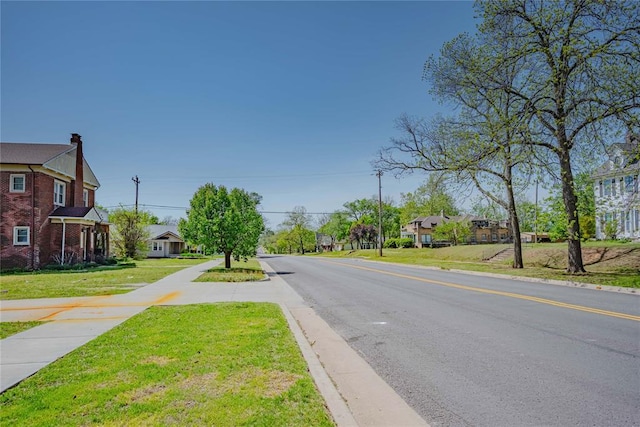 view of street with curbs, sidewalks, and a residential view
