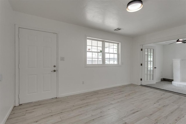 entrance foyer featuring light wood-style floors, a ceiling fan, and a healthy amount of sunlight