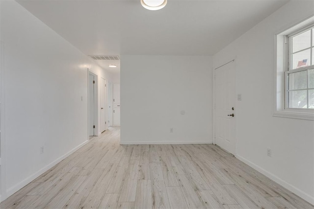 spare room with visible vents, light wood-style flooring, and plenty of natural light