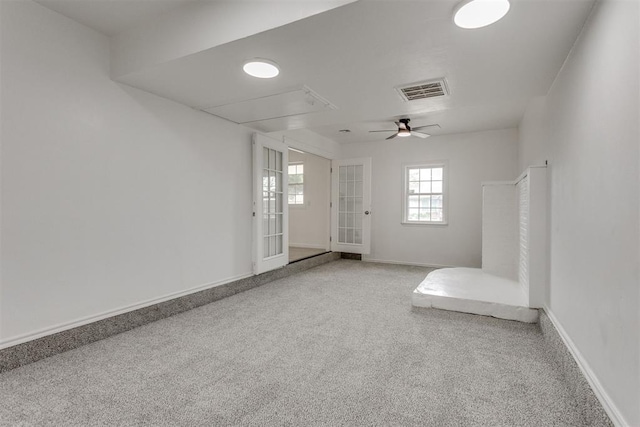foyer with visible vents, carpet flooring, baseboards, and a ceiling fan