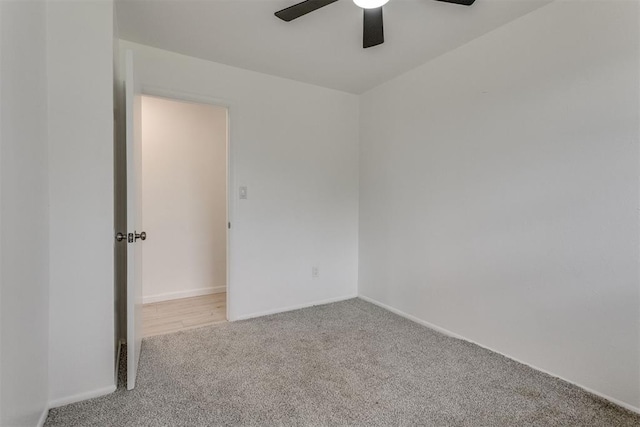 carpeted empty room featuring a ceiling fan and baseboards