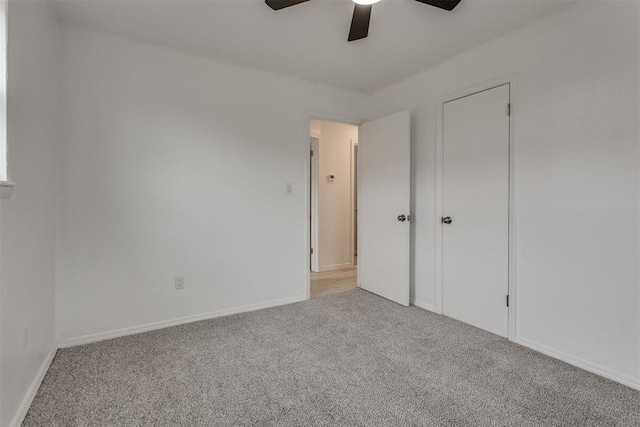 unfurnished bedroom with baseboards, a ceiling fan, and carpet