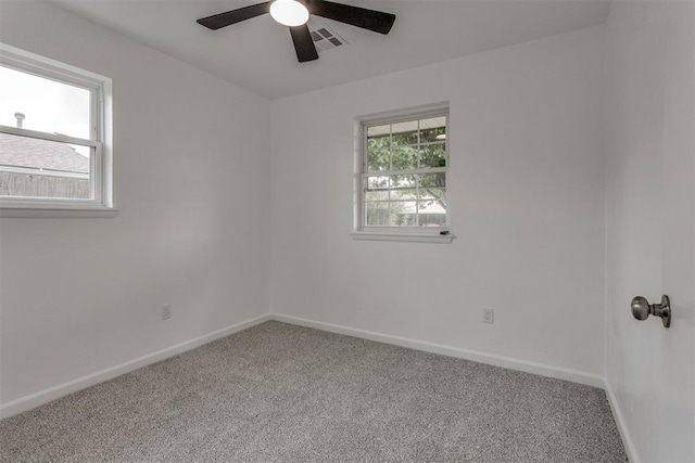 empty room with carpet floors, baseboards, visible vents, and ceiling fan