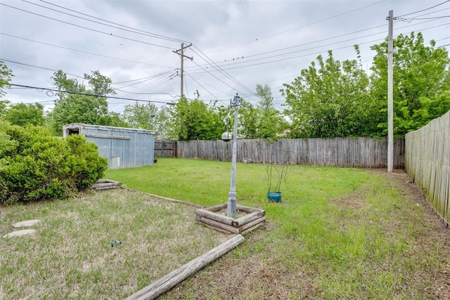 view of yard with a fenced backyard and an outbuilding