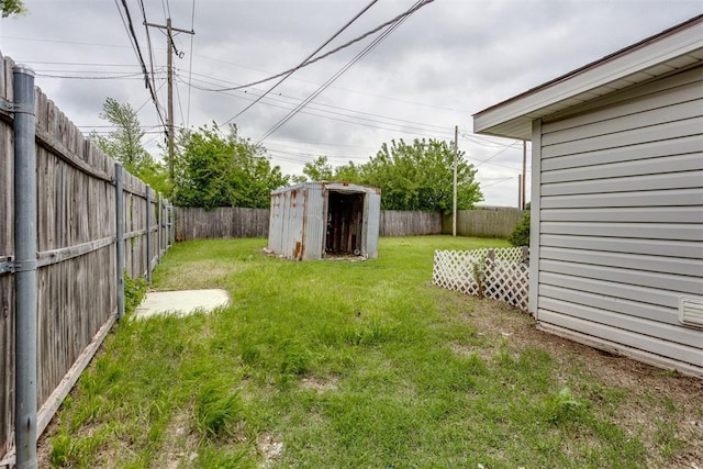 view of yard featuring a storage shed, an outbuilding, and a fenced backyard