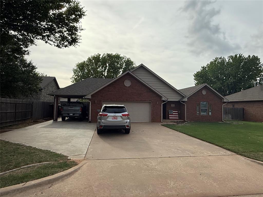 view of front of house with brick siding, fence, a front yard, and a garage