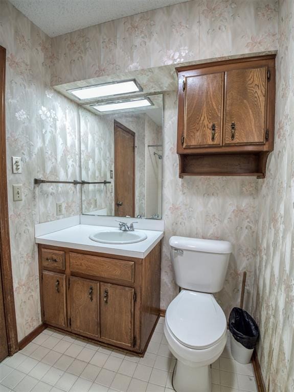 bathroom featuring toilet, wallpapered walls, tile patterned floors, a textured ceiling, and vanity