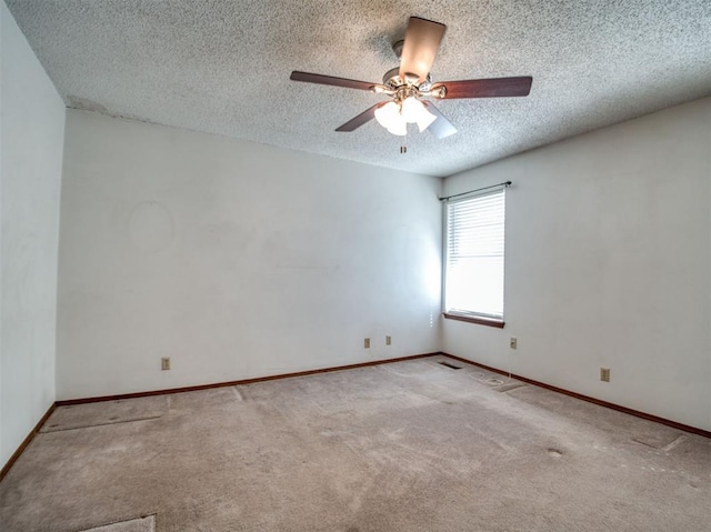 spare room featuring carpet flooring, a textured ceiling, baseboards, and a ceiling fan