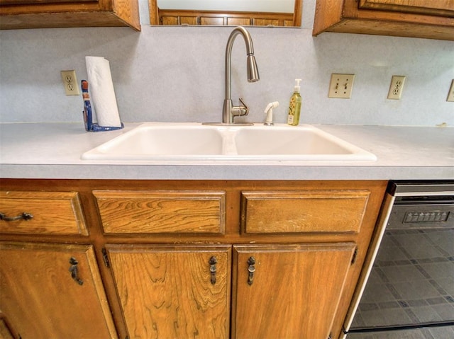 room details featuring brown cabinetry, light countertops, and a sink