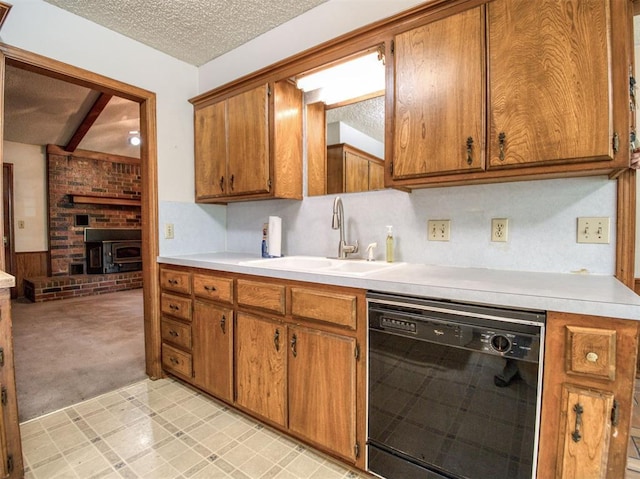 kitchen with light countertops, black dishwasher, brown cabinetry, and a sink