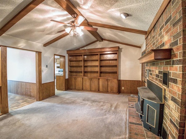 interior space with wooden walls, vaulted ceiling with beams, wainscoting, and a textured ceiling