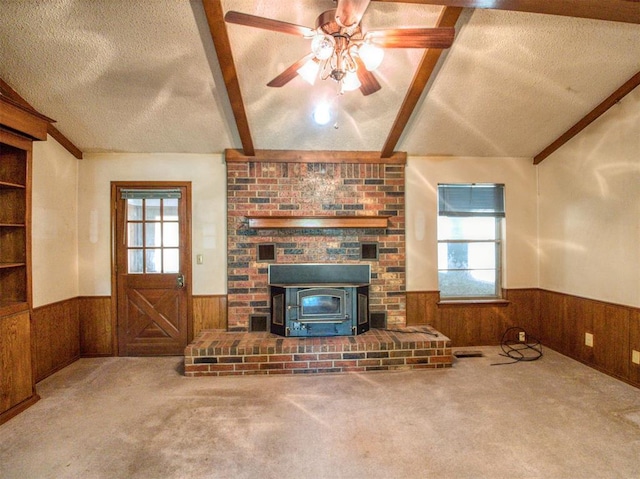 unfurnished living room featuring wainscoting, a textured ceiling, and a wealth of natural light