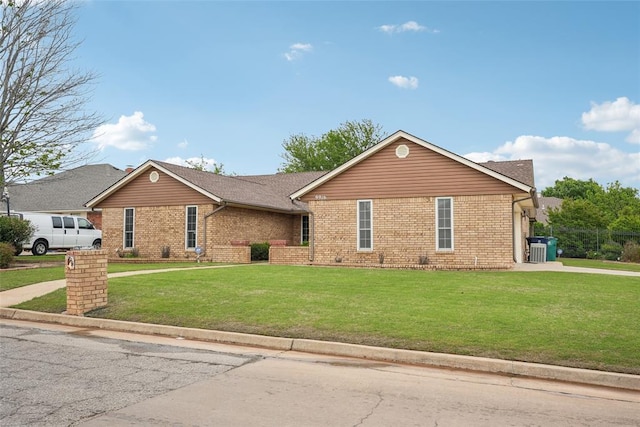 single story home with driveway, a front lawn, and brick siding