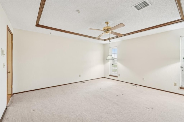 spare room with a raised ceiling, ceiling fan, a textured ceiling, and visible vents