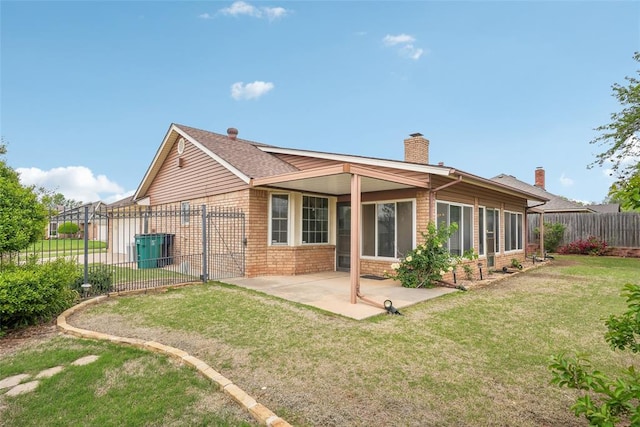 rear view of house featuring a fenced backyard, a chimney, brick siding, a patio area, and a yard